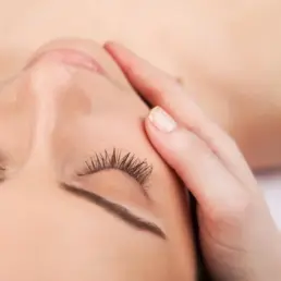 Woman receiving relaxing facial massage treatment at Beauty Refined