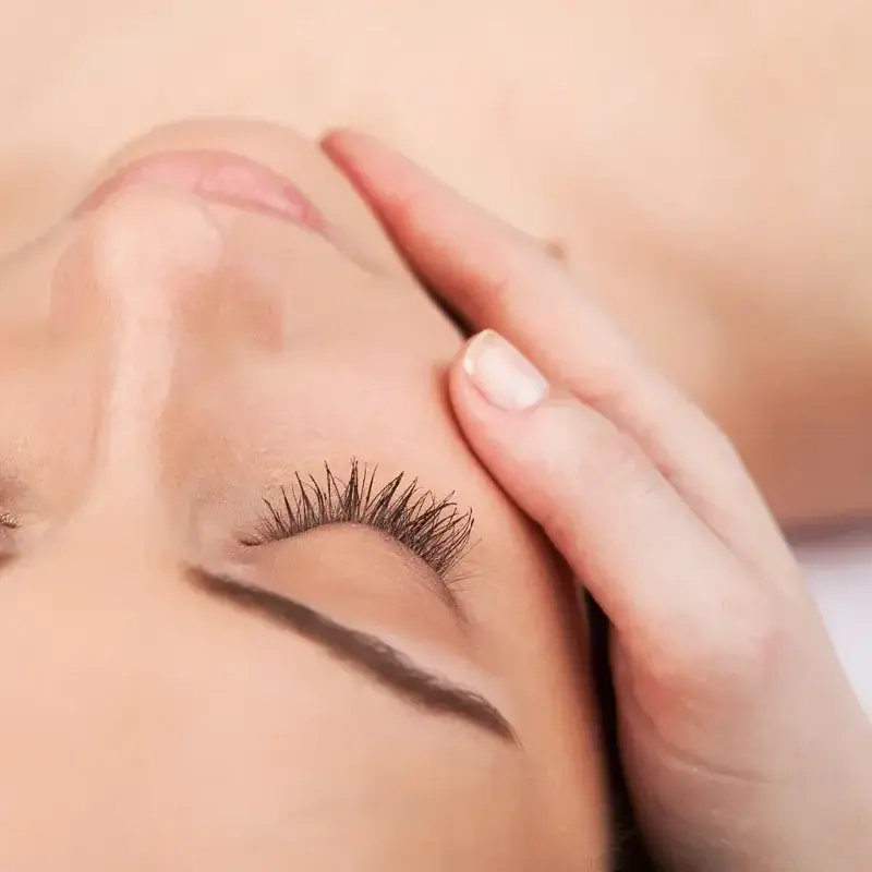 Woman receiving relaxing facial massage treatment at Beauty Refined