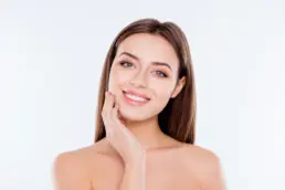 Smiling woman with clear glowing skin after facial treatment
