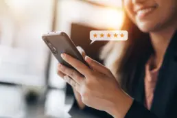 Customer leaving positive online review on mobile phone